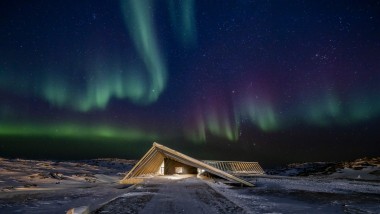 L’Icefjord Centre sous les spectaculaires aurores boréales de la nuit polaire groenlandaise (© Adam Mørk)